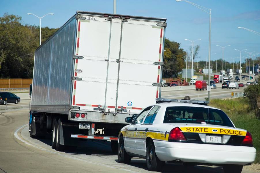 Illinois State Police patrol car parked by a semi for the trooper in a truck program.