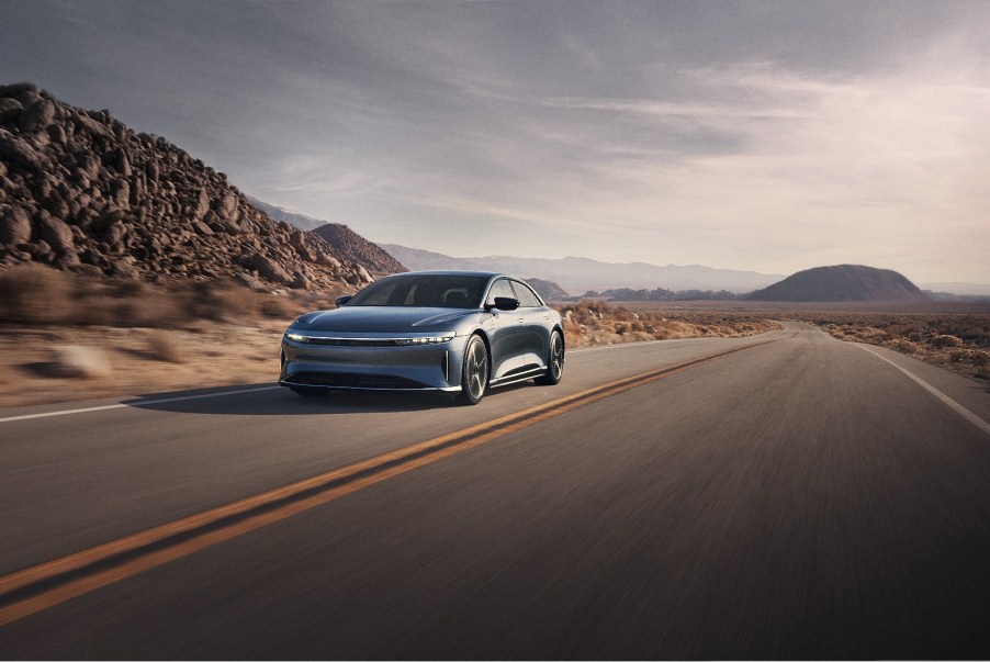A Lucid Air Pure EV sedan driving in left front view