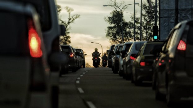 The tail lights of a motorcycle filtering lanes in Colorado at sunset