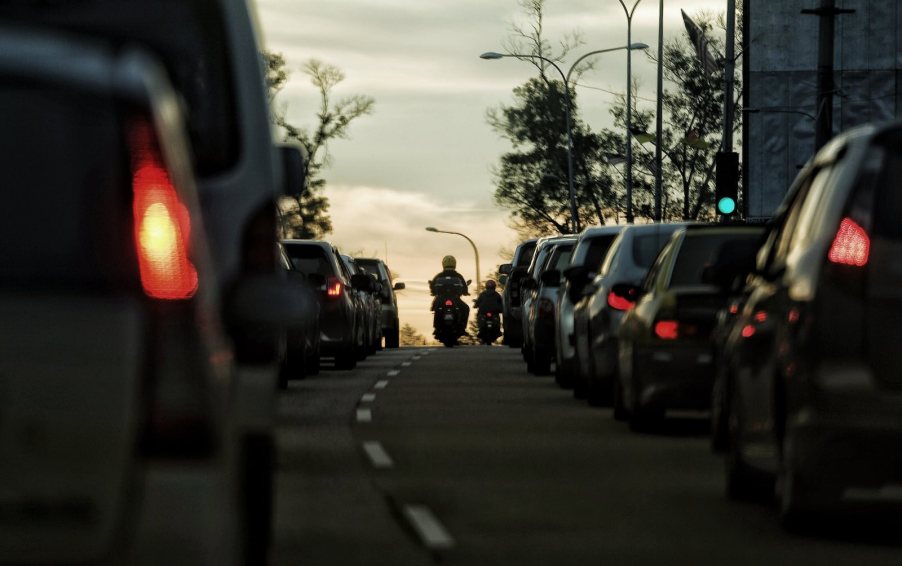 The tail lights of a motorcycle filtering lanes in Colorado at sunset