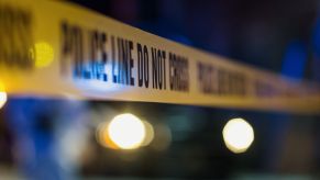 A police line at a crime scene involving a Florida man, a gun, and a blocked car.
