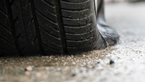Closeup of the flat tire under a San Francisco police cruiser that ran over its own spike strip