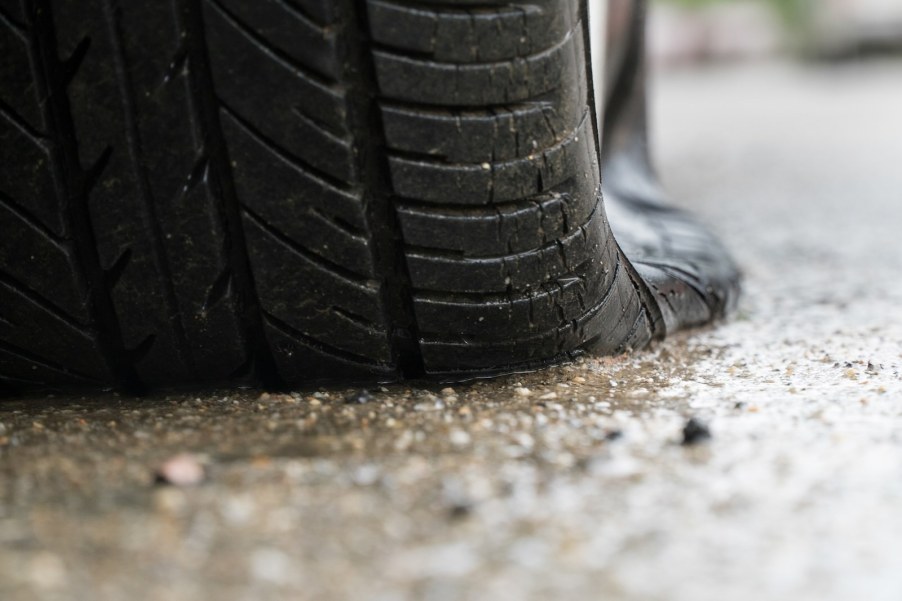 Closeup of the flat tire under a San Francisco police cruiser that ran over its own spike strip
