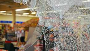 The smashed window at the front of a store from a robbery.