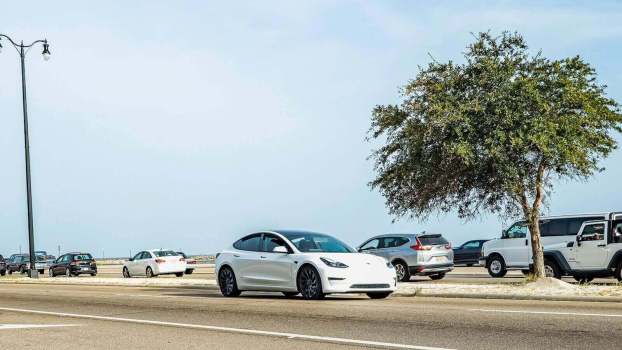 A pre-facelift Tesla Model 3 driving.