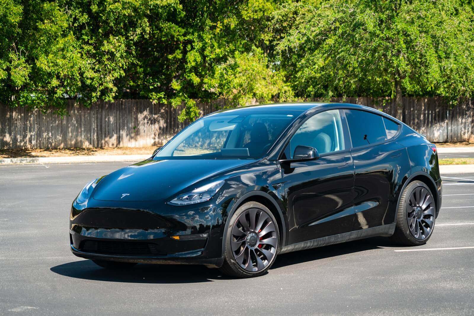 A black Tesla Model Y, the top performer of the best-selling EVs, parked in a lot.