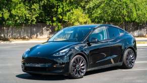 A black Tesla Model Y, the top performer of the best-selling EVs, parked in a lot.