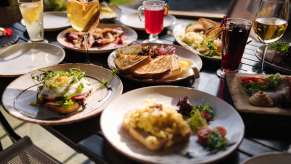A large spread of brunch food and drinks set at a restaurant table
