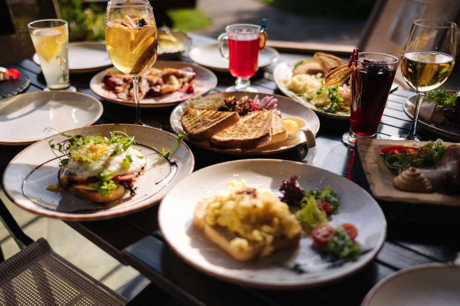 A large spread of brunch food and drinks set at a restaurant table