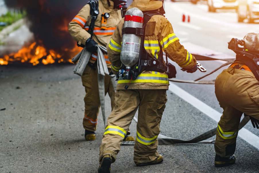 Firefighters responding to a car fire in close view from necks down