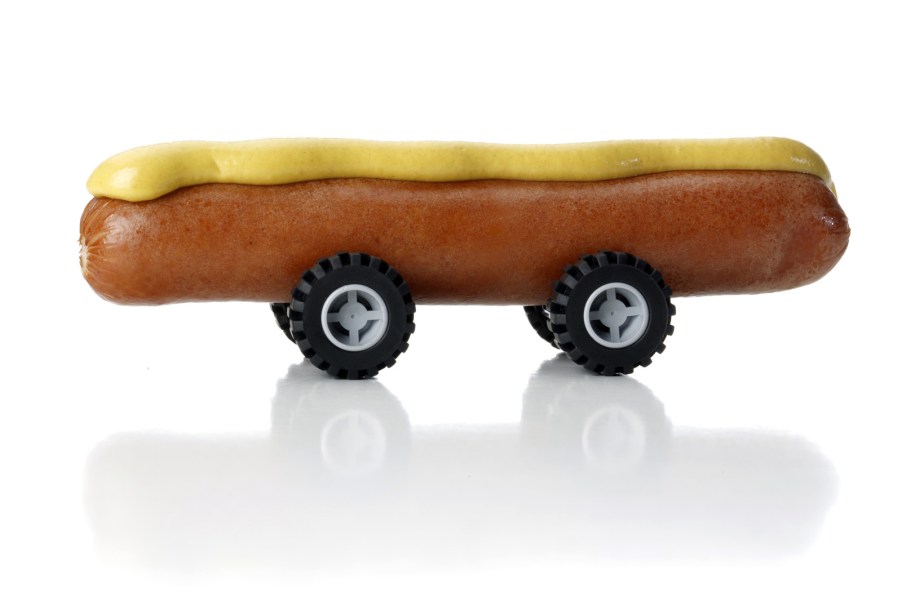 A hot dog with mustard on toy wheels