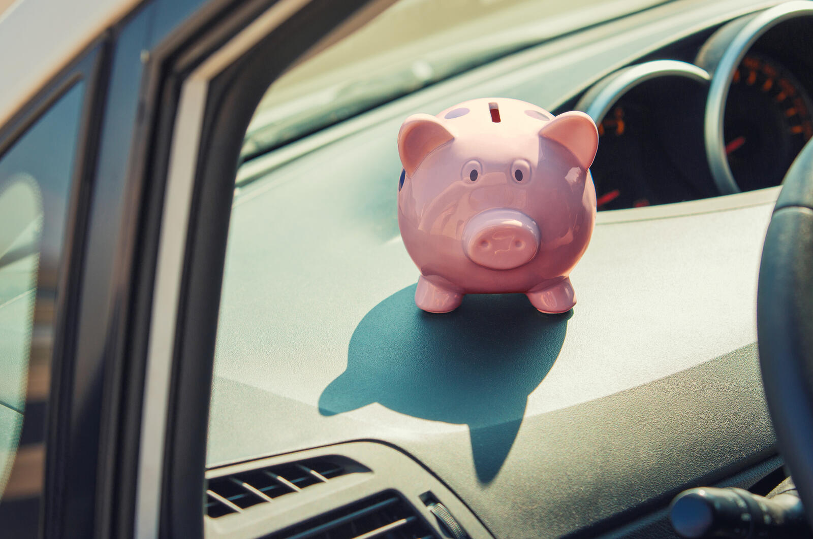 A piggy bank sitting on a car dash
