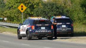 A set of police SUVs at an emergency scene involving inmates.