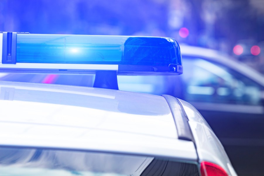 A close-up view of a police cruiser roof with blue lights on