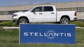 A Stellantis brand sign in front of a white Ram 1500 pickup truck