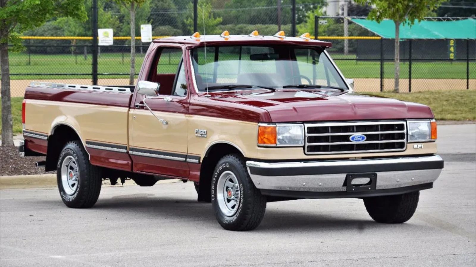 A maroon and tan 1990 Ford F-150 XLT Lariat 5-Speed parked in right front angle view