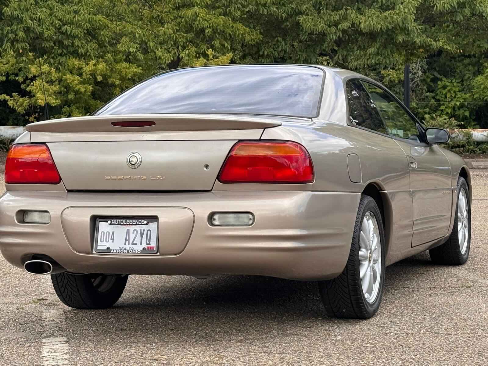 The rear of a beige Chrysler Sebring Coupe in a parking lot