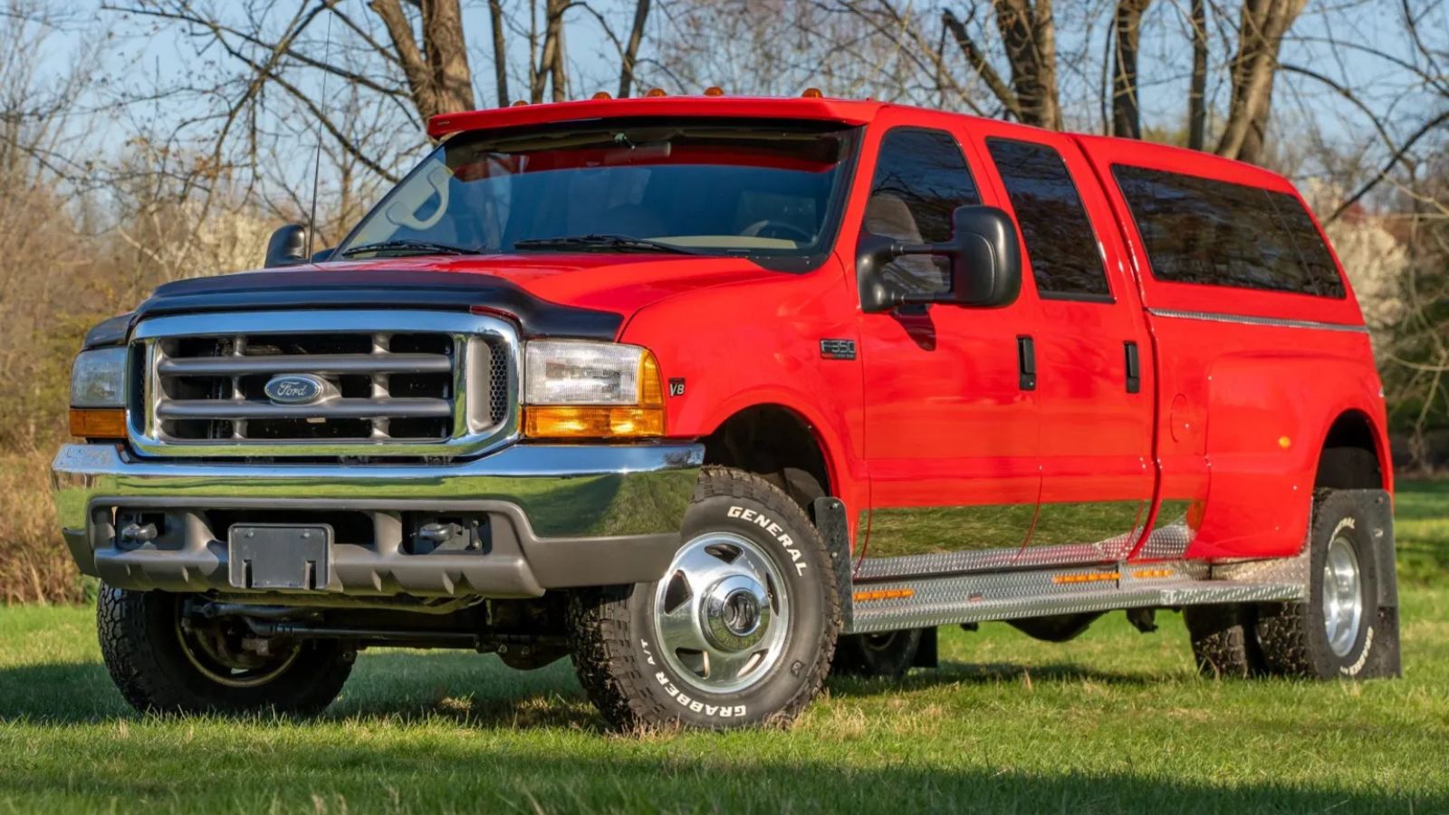 A red 1999 Ford F-350 Super Duty Lariat Crew Cab Power Stroke 4×4 Dually parked in left front angle view
