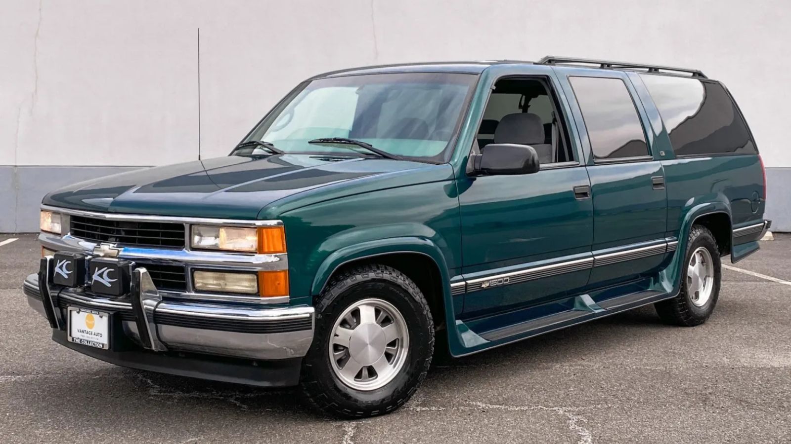 A green 1999 Chevrolet Suburban C1500 LS parked in left front angle view