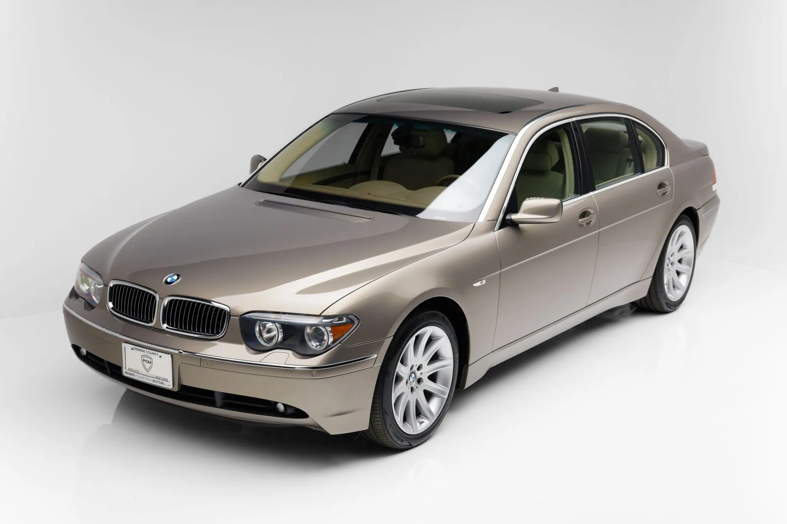 A champagne 2002 BMW 745Li parked in aerial left front angle view