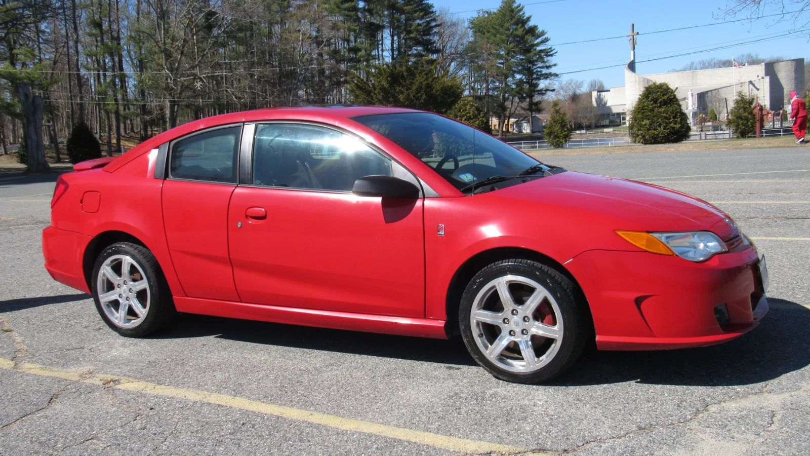 A bright red 2005 Saturn Ion parked in right side view