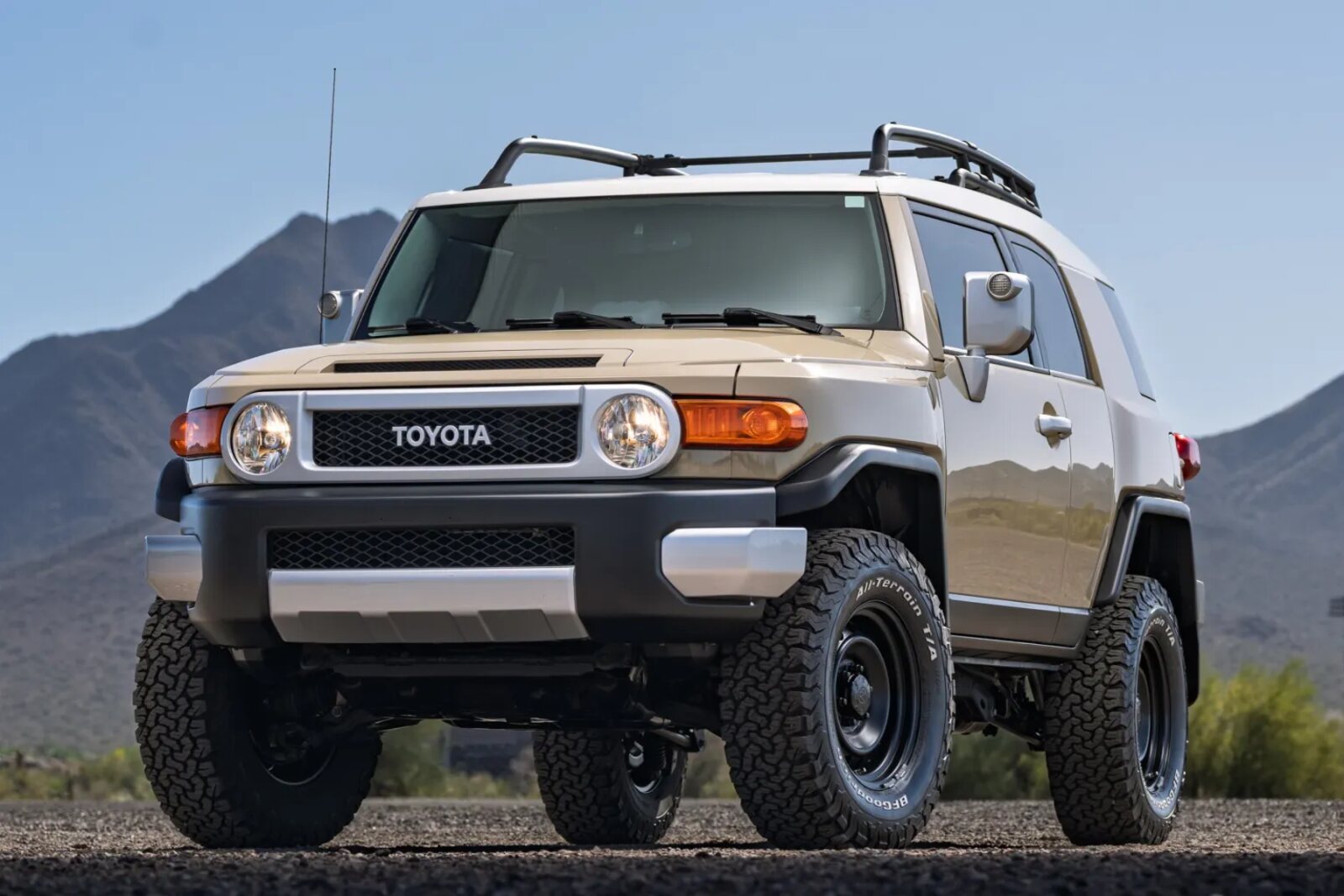 A champagne 2014 Toyota FJ Cruiser parked in close left front angle view