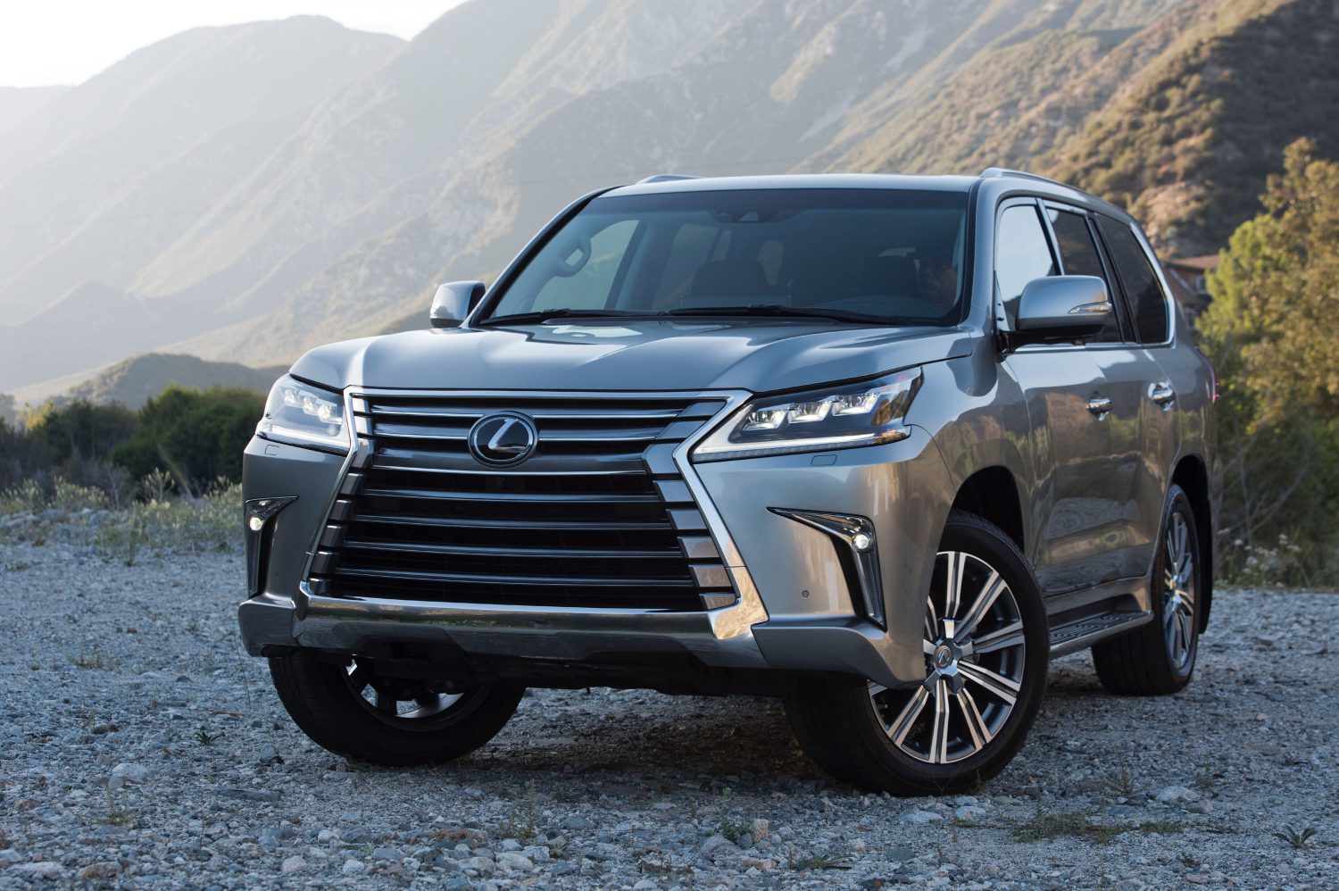 A grey 2018 Lexus LX 570 parked on mountainous gravel in left front angle view