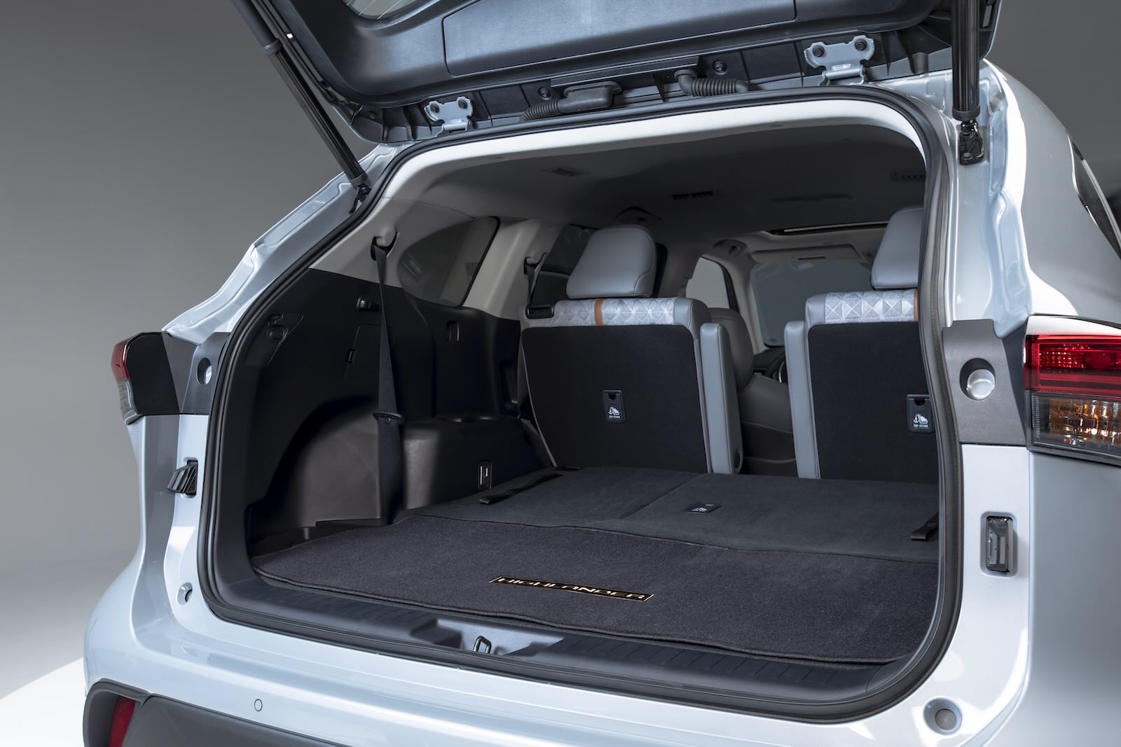The rear of a third-row Toyota Highlander crossover SUV with its hatch up and seats down.