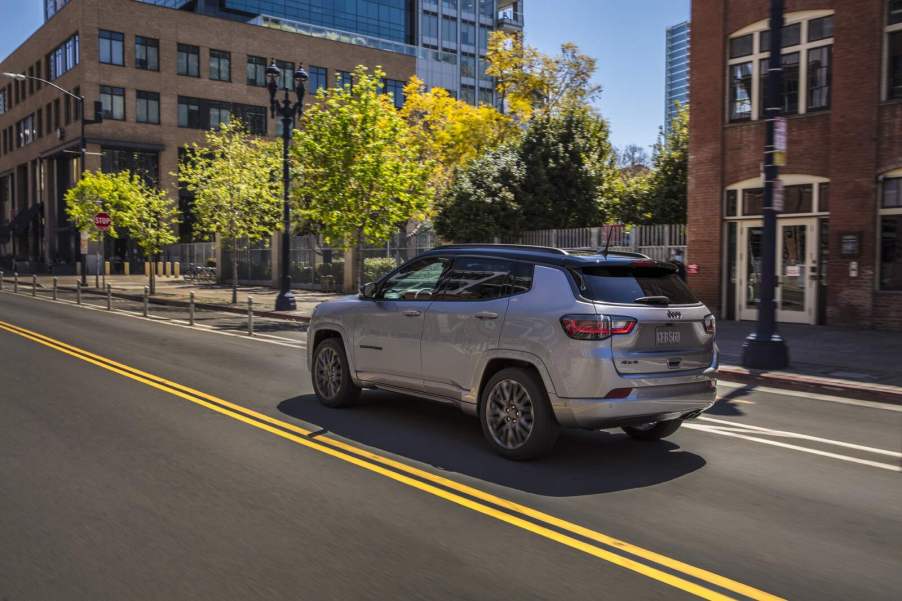 A silver 2023 Jeep Compass on a city street in left rear angle view