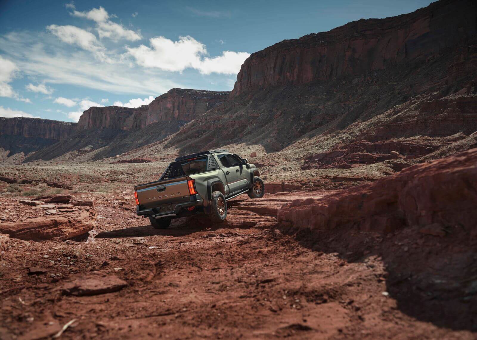 A 2025 Toyota Tacoma, one of the best vehicle models for depreciation, climbs over rocks and shelves.