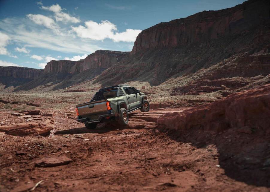 A 2025 Toyota Tacoma, one of the best vehicle models for depreciation, climbs over rocks and shelves.