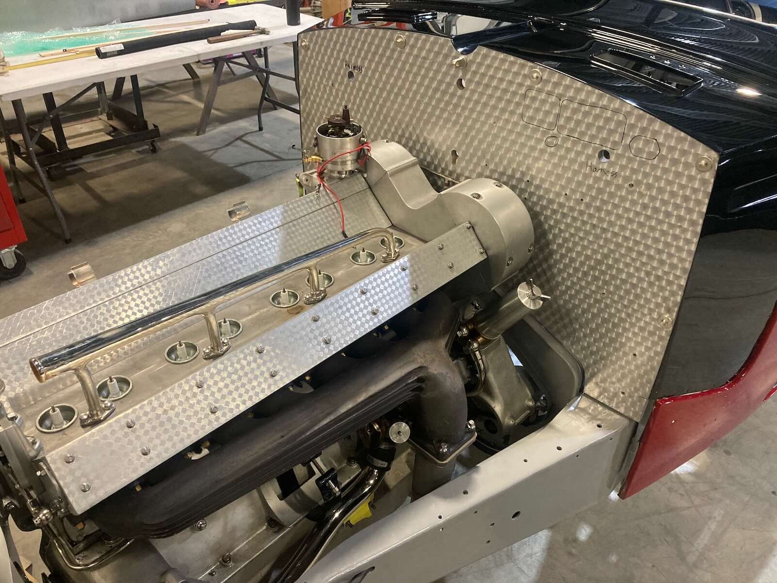 Engine bay of a vintage Bugatti grand touring car undergoing restoration