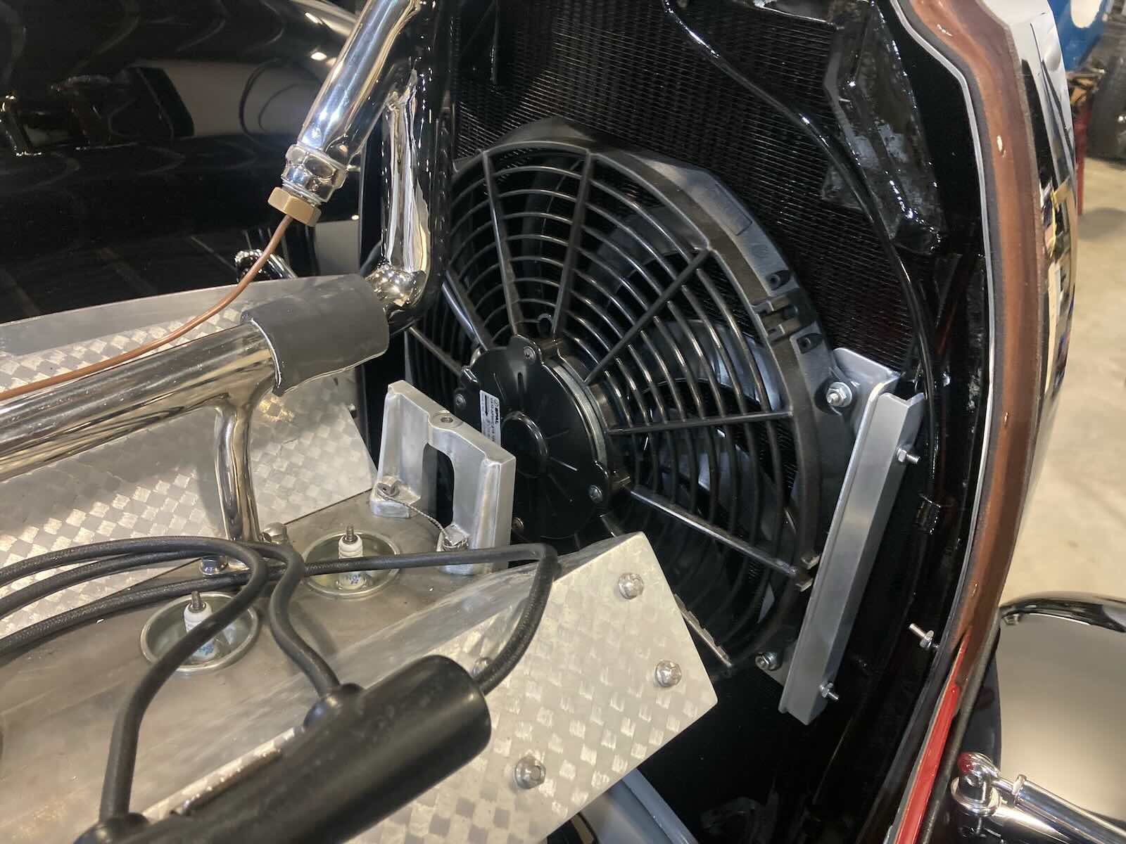 Engine bay of a vintage Bugatti grand touring car undergoing restoration