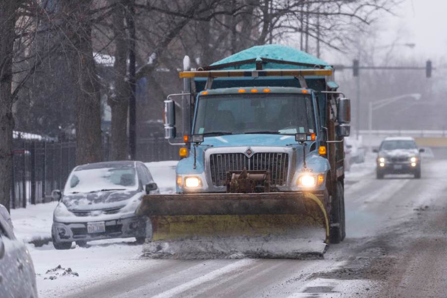 Light blue Chicago department of streets and sanitation plow truck on a city street.
