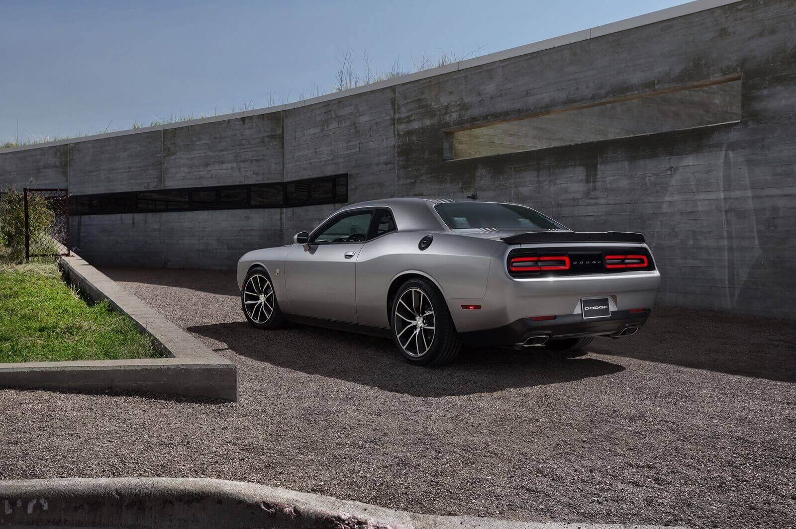 A Dodge Challenger R/T Scat Pack Shaker parked alongside a modern building. 