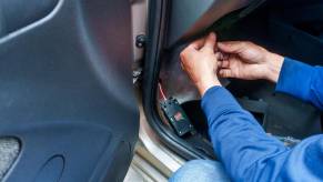 Florida man's hands as he installs GPS tracker on stalking victim's car.