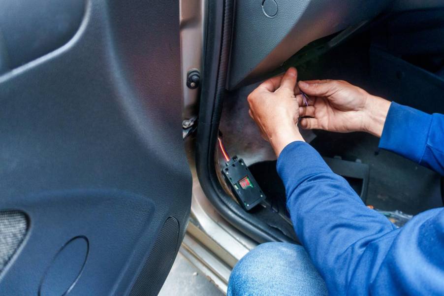 Florida man's hands as he installs GPS tracker on stalking victim's car.