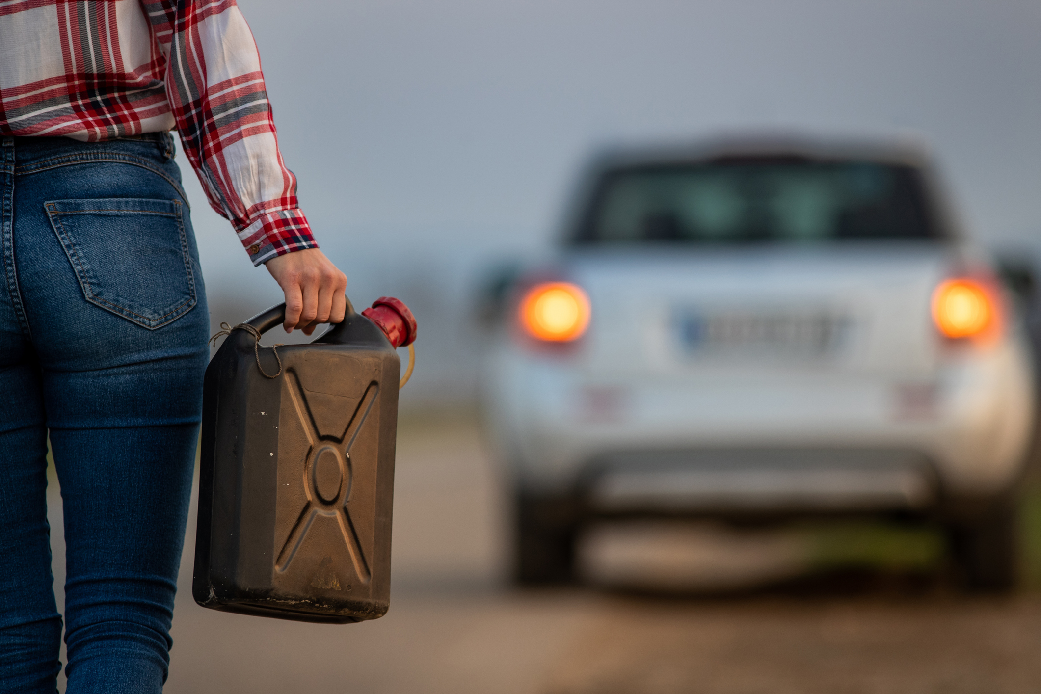 A woman holding a gas can