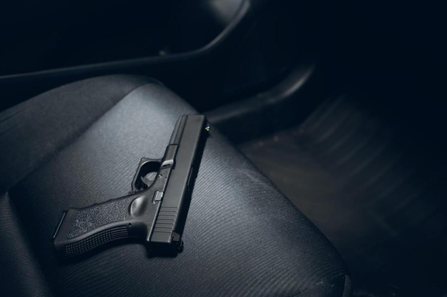 An image shows a replica gun in a car, sitting on the seat.