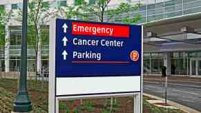 Hospital Cancer Center and Emergency Room parking sign, trees visible in the background.
