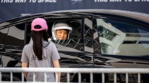 Japanese astronaut Takuya Onishi smiles at a fan from a car while parading to the SpaceX rocket launch.