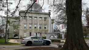 North Carolina police squad car parked in front of the state house, under a tree.