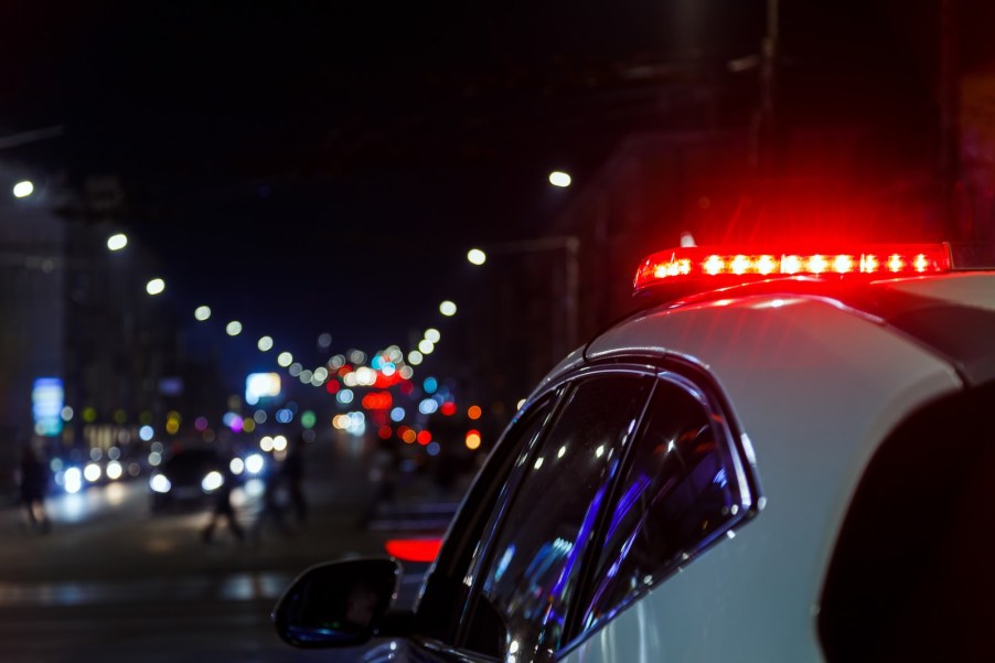 The red lights atop a police cruiser after it pulls over Dodge Charger EV for noise violation