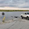 An image shows a RAM pickup truck backing up to the water to launch a boat.