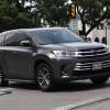 Gray Toyota Highlander crossover SUV with Texas license plates in city traffic.