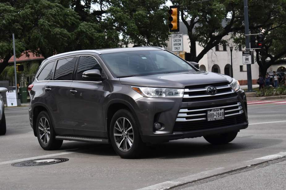 Gray Toyota Highlander crossover SUV with Texas license plates in city traffic.