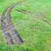 Truck tracks left in the grass of a golf course during a police chase.