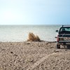 A truck in the sand on the beach
