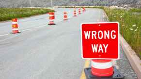 Wrong way sign, with a highway on ramp blockade behind it