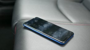 A cell phone sitting on a leather car seat